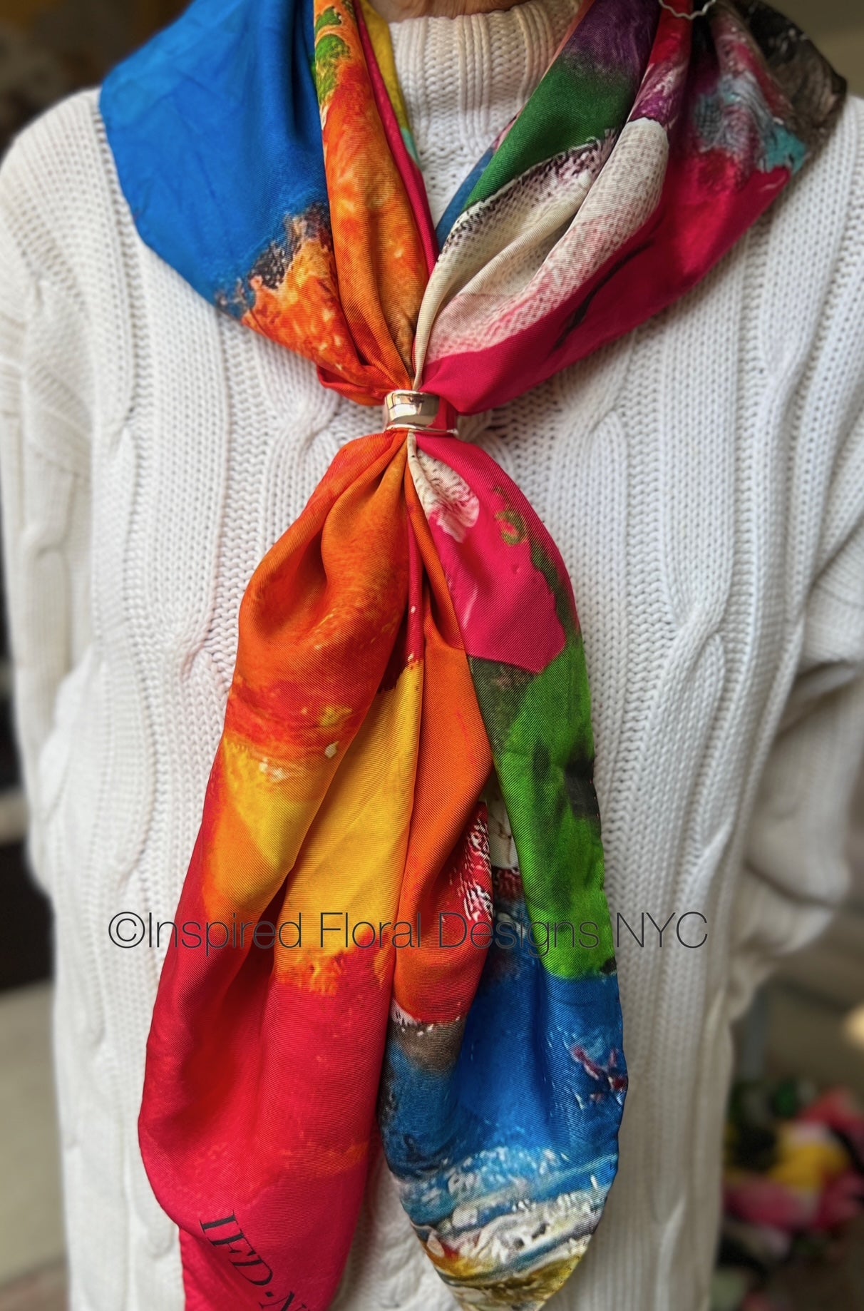 Colorful scarf tied around a person's neck with a blurred background inspired floral designs nyc copyright fragmented blossoms