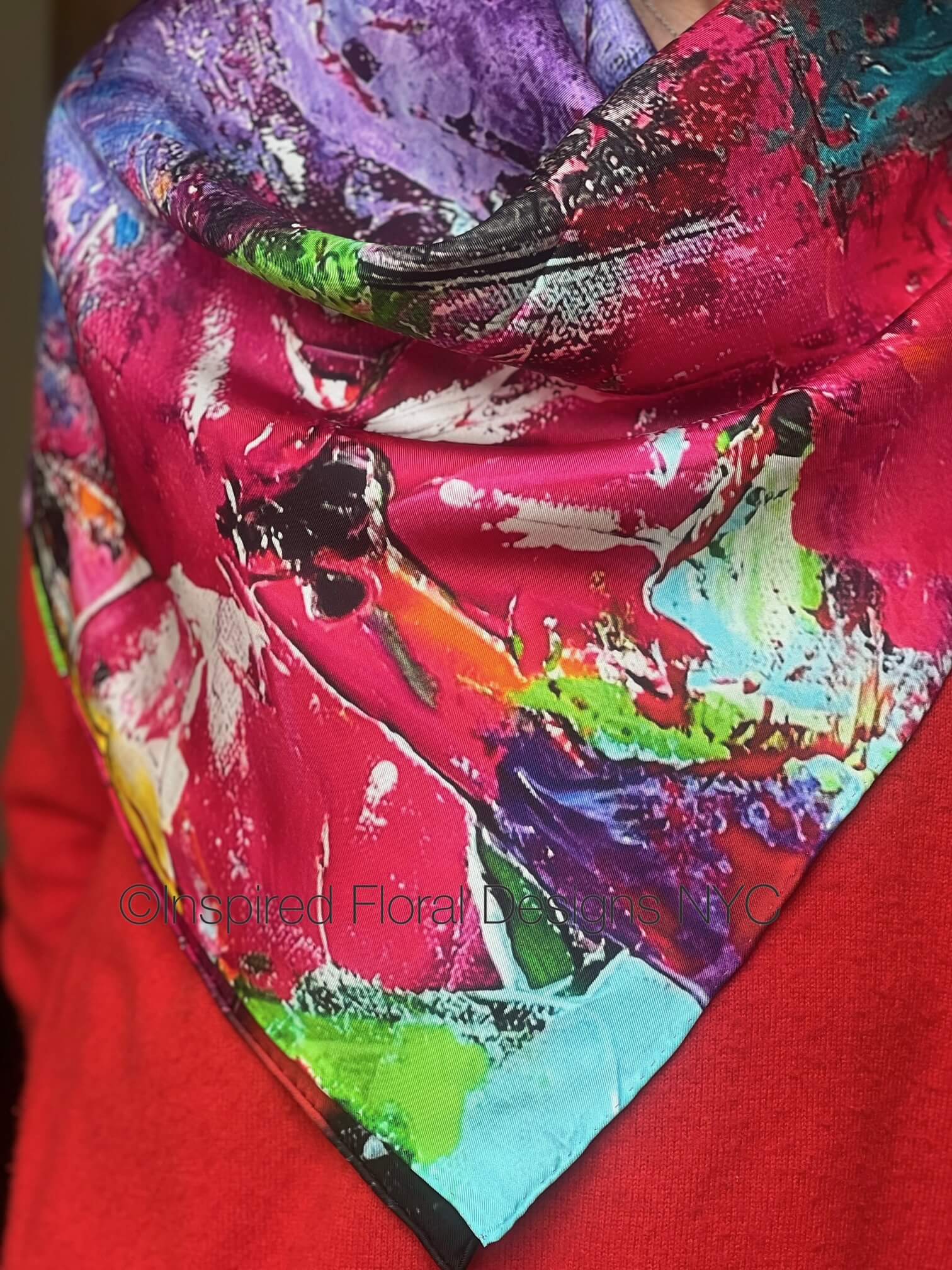 Colorful abstract floral scarf draped over a red background titled petals in the wild by inspired floral designs nyc brand copyright