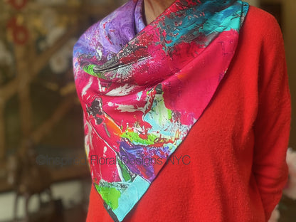 Person wearing a colorful floral abstract scarf titled petals in the wild by inspired floral designs nyc brand on a blurred background copyright