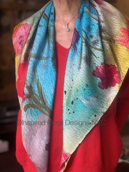 Person wearing a colorful floral scarf with 'inspired Floral Designs NYC' branding titled floral symphony copyright