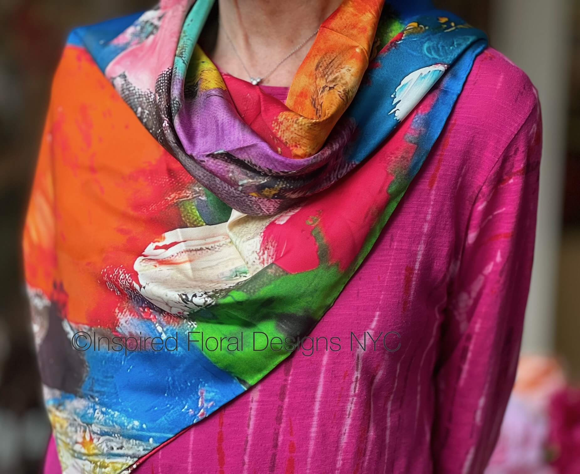 Person wearing a colorful scarf fragmented blossoms with artistic design on a blurred background inspired floral designs nyc llc