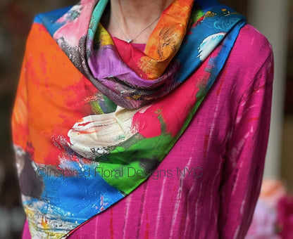 Person wearing a colorful scarf fragmented blossoms with artistic design on a blurred background inspired floral designs nyc llc