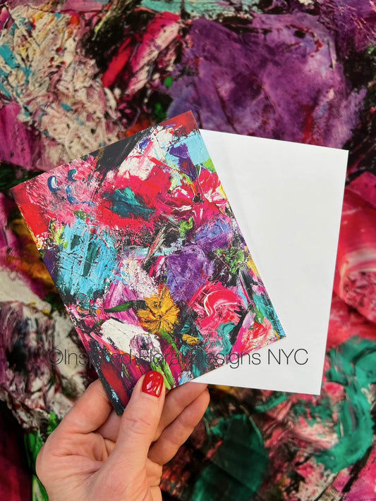 Colorful abstract art card held by a hand with a white card displaying Inspired Floral Designs NYC on a textured background copyright