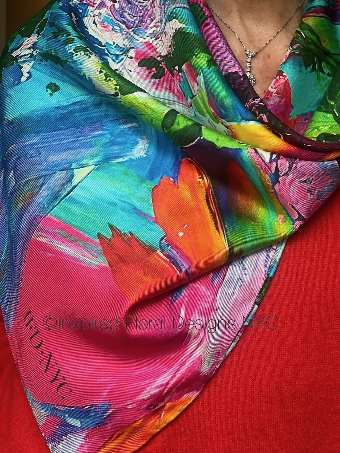 Colorful floral scarf with abstract floral patterns on a red background, featuring the brand inspired floral designs nyc petals unleashed copyright 