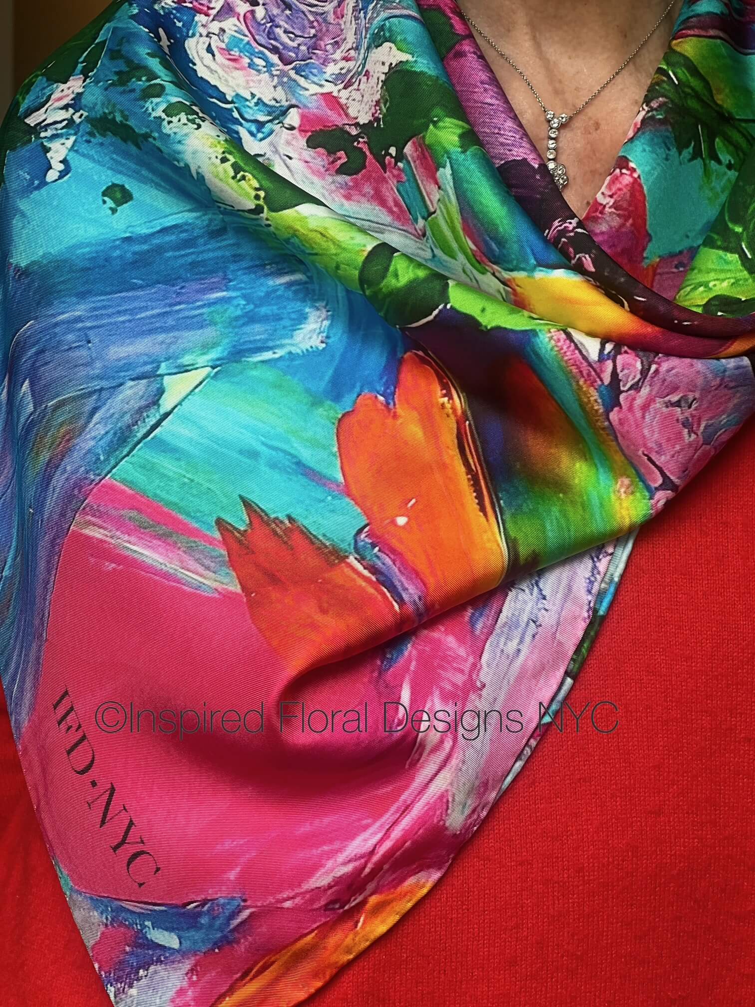 Colorful floral scarf with abstract floral patterns on a red background, featuring the brand inspired floral designs nyc petals unleashed copyright 