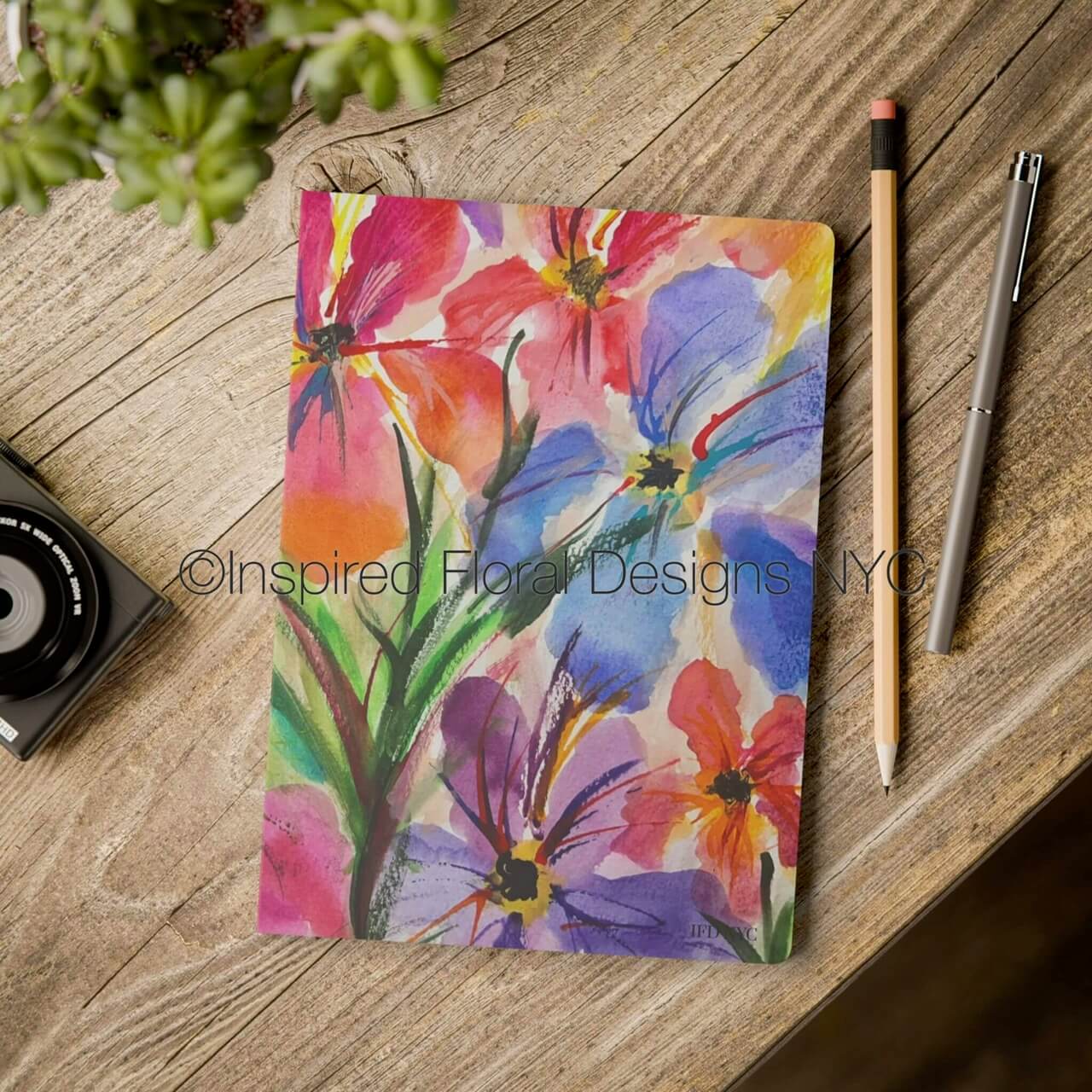 Floral notebook on a wooden surface with stationery items by inspired floral designs nyc