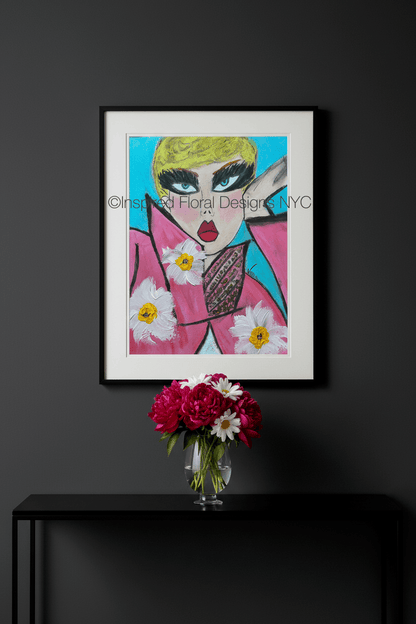Framed artwork of a stylized face with flowers on a dark wall above a black console table with a vase of flowers by inspired floral designs nyc llc copyright