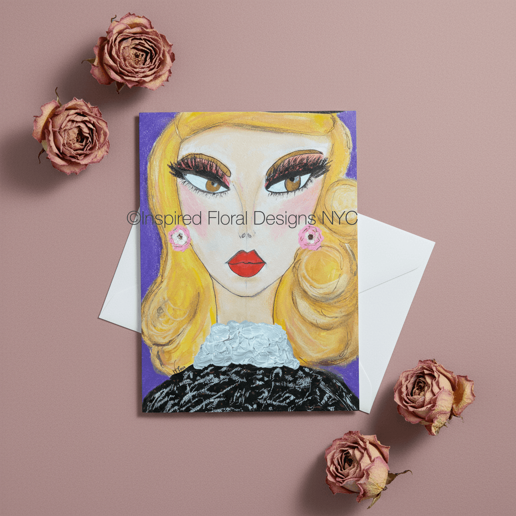 A greeting card featuring a stylized illustration of a blonde woman with bold makeup and red lips, shown with a white envelope on a dusty pink background with dried pink roses around it by Whitney at Inspired Floral Designs NYC LLC.  A watermark reading 'Inspired Floral Designs NYC' is visible across the artwork copyright.