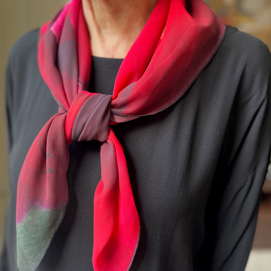 his stunning red floral scarf is entitled Amour. The colors are vibrant and perfect for a gorgeous pop of color around the neck, as a head scarf or even for the dog! 