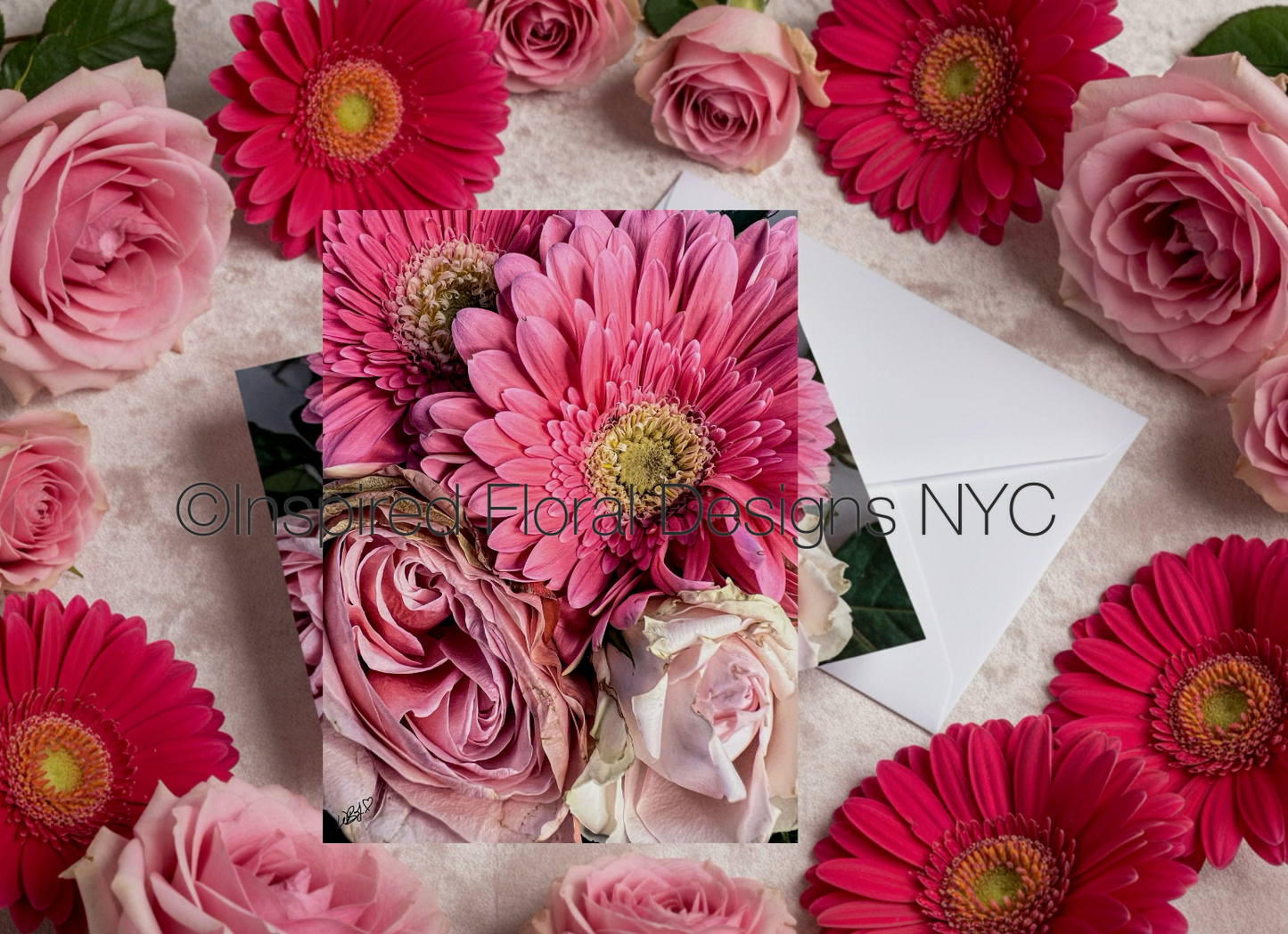 Floral arrangement with pink and red flowers on a textured surface, featuring 'Inspired Floral Designs NYC'.