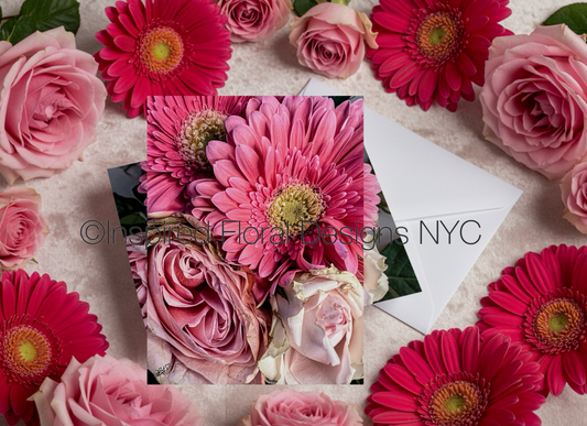 Floral arrangement with pink and red flowers on a textured surface, featuring 'Inspired Floral Designs NYC'.